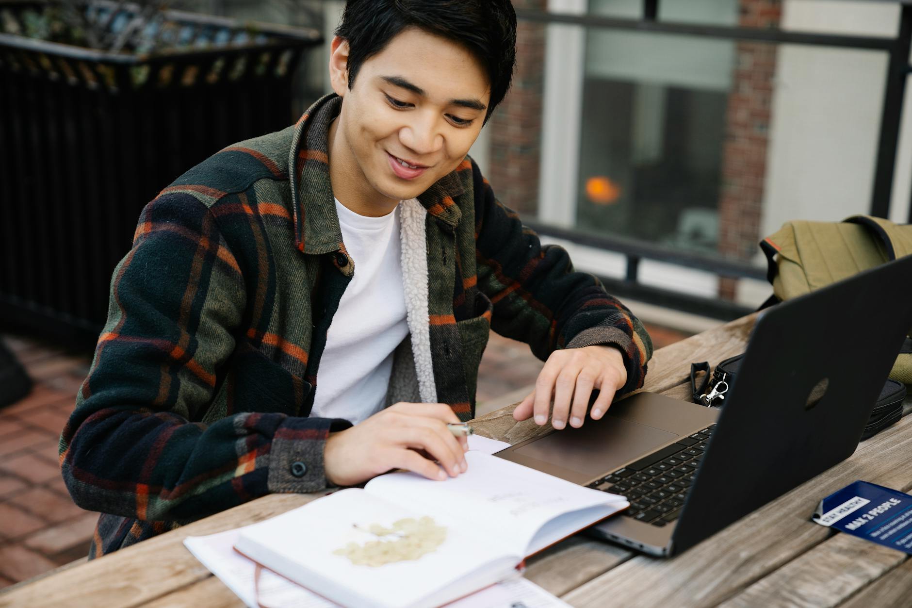 young man looking at notebook and laptop picture